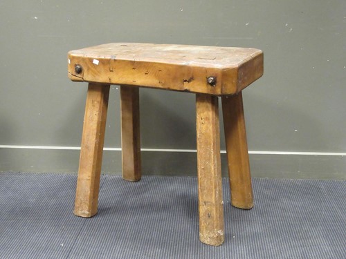Lot 428 - An elm butchers block on four chamfered legs....