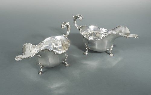 Lot 448 - A near pair of George V silver sauce boats with earlier ladles