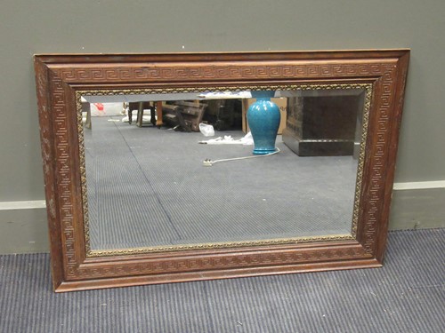 Lot 565 - An bevelled edge rectangular mirror in an oak...