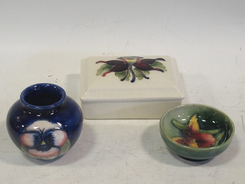 Lot 30 - Moorcroft: a small vase, a bowl and a lidded...