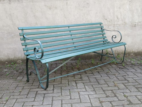 Lot 577 - A green painted garden bench with metal scroll...