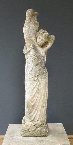 Lot 582 - A composite stone garden figure of a female...