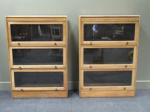 Lot 459 - A pair of oak Globe Wernike style bookcases...