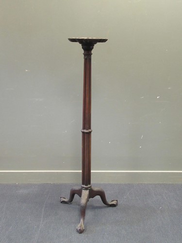 Lot 493 - A mahogany torchere with pie crust top over a...