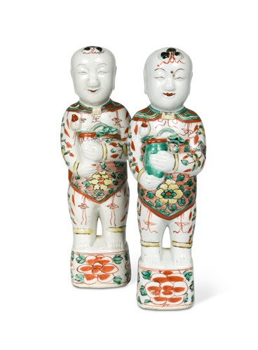 Lot 106 - A Pair of Chinese famille verte porcelain standing smiling boys, Qing Dynasty, Kangxi (1662-1722)