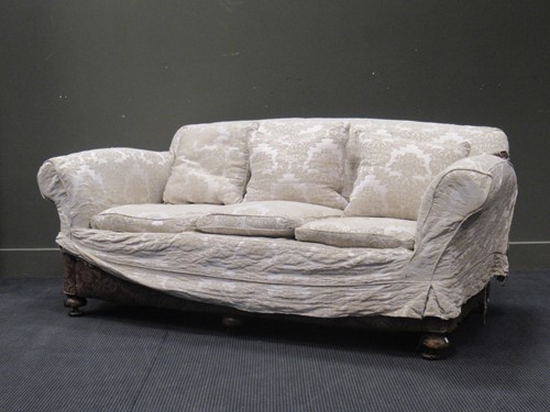 Lot 519 - An Edwardian three seater sofa raised on bun...