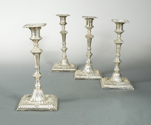 Lot 374 - A set of four early George III 18th century cast silver candlesticks