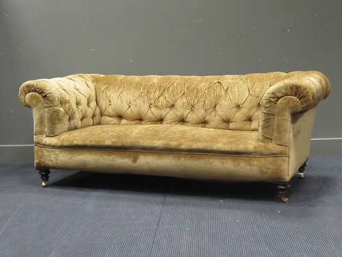 Lot 577 - A Chesterfield sofa, on turned legs with brass...