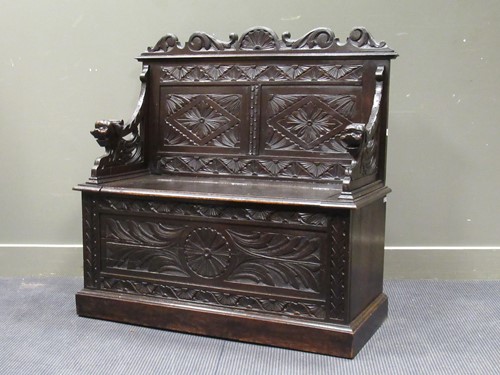 Lot 505 - A late Victorian carved oak box seat settle...