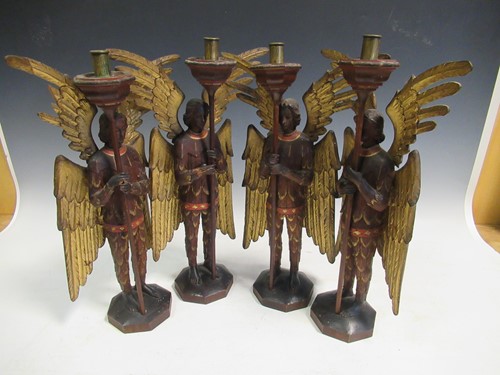 Lot 34 - A set of four carved and gilt candlesticks...