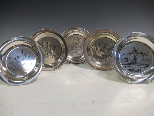 Lot 198 - A set of five silver side plates, decorated...