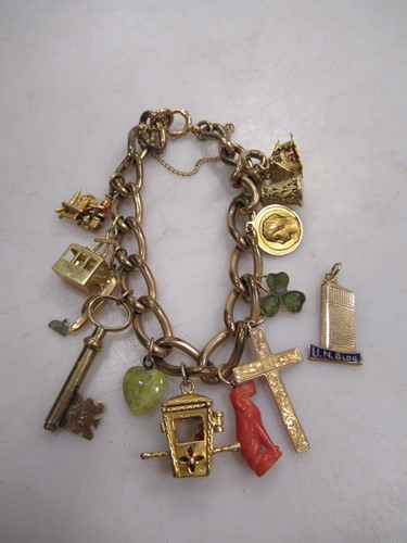 Lot 185 - A charm bracelet and charms, the clasp marked...