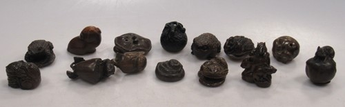 Lot 112 - Fourteen carved wood netsuke including toads,...