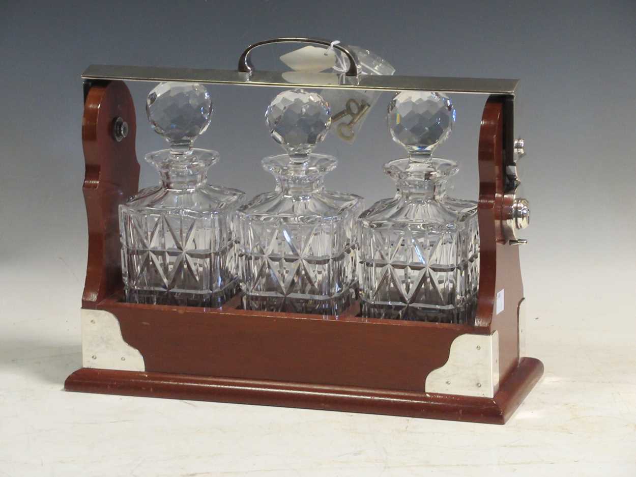 Lot 30 - A modern three decanter tantalus with plated...