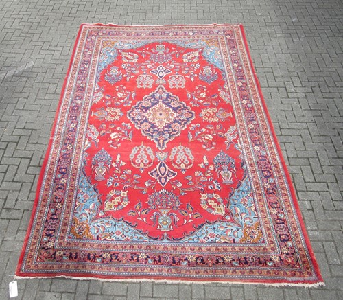 Lot 645 - A red ground carpet with central medallian and...