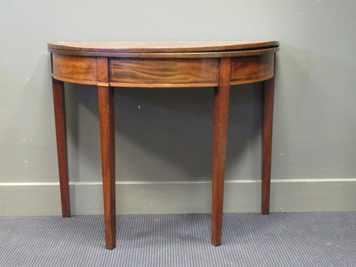Lot 535 - A 19th mahogany demi lune fold over top tea...