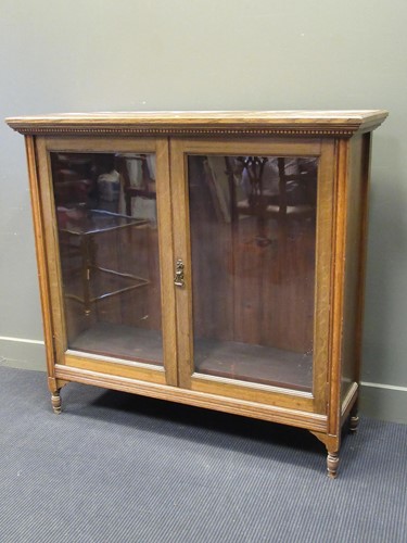 Lot 472 - An Edwardian blonde oak bookcase with a carved...