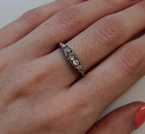 Lot 180 - A diamond carved head half hoop ring,...