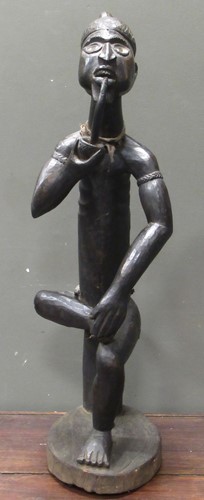 Lot 171 - A 20th century African carved figure of seated...