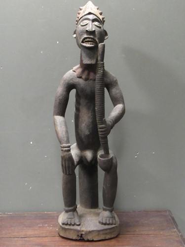 Lot 170 - An African carved wood figure of a seated male...