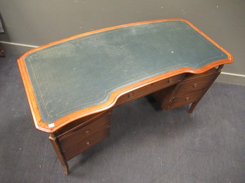 Lot 528 - A 20th century curved writing desk with green...