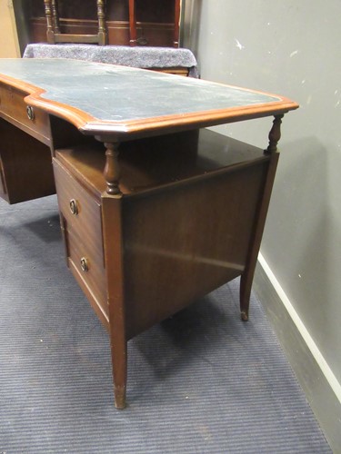 Lot 528 - A 20th century curved writing desk with green...
