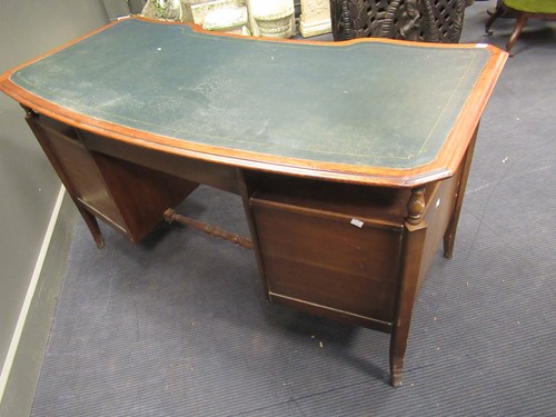 Lot 528 - A 20th century curved writing desk with green...