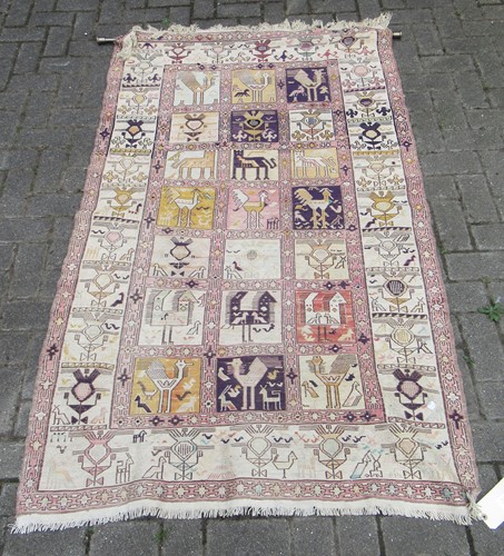 Lot 652 - A tribal pale ground rug with bands of animals...