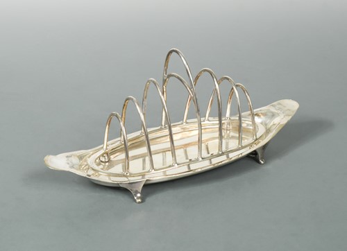 Lot 463 - A George V silver seven bar toast rack with integral crumb tray
