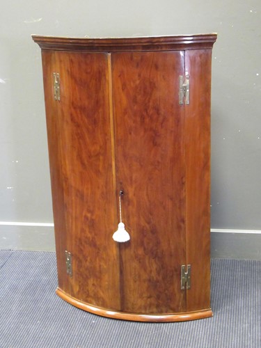 Lot 361 - A 19th century bow fronted corner cupboard...