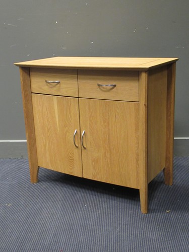 Lot 438 - A contemporary bow-fronted pale oak side cabinet