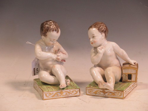 Lot 129 - A pair of Meissen bookends, modelled as seated...