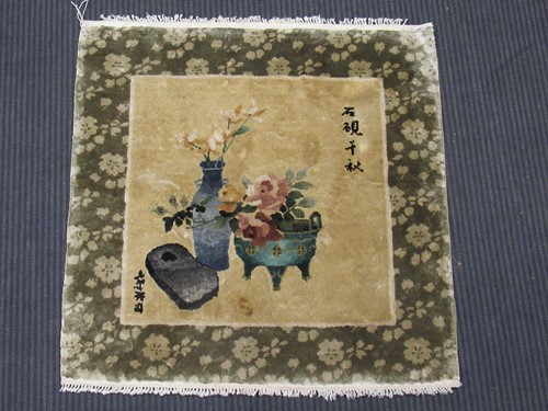 Lot 587 - A small Chinese woolen rug depicting a vase of...