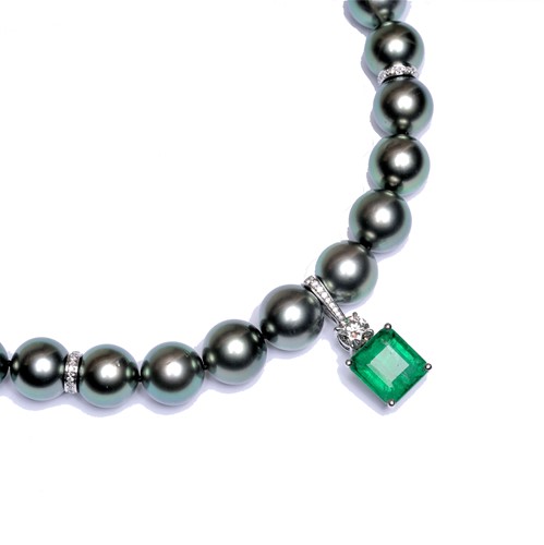 Lot 171 - A single row of peacock coloured Tahitian cultured pearls with an emerald and diamond pendant