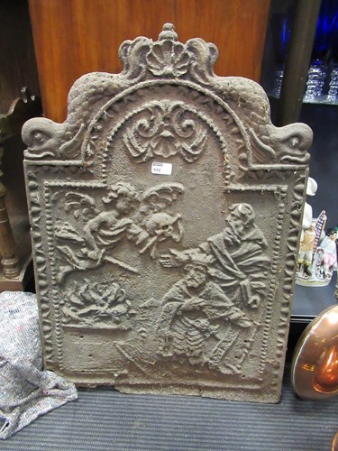 Lot 550 - A cast iron fire back decorated with a cherub...