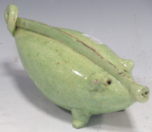 Lot 34 - A green glazed pottery 'pig' form money box,...