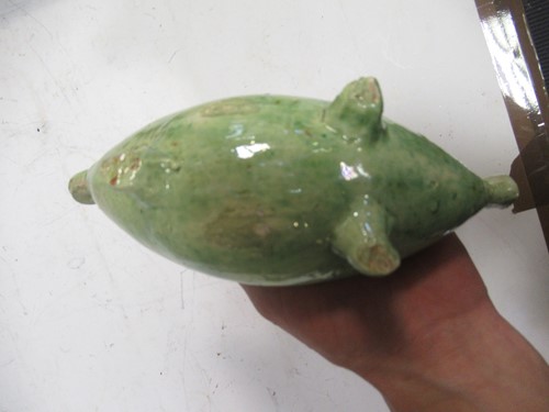 Lot 34 - A green glazed pottery 'pig' form money box,...