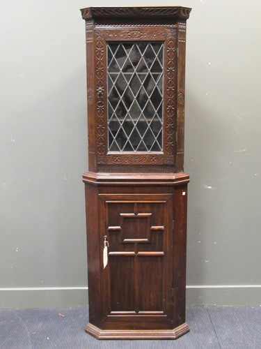 Lot 404 - An oak standing bookcase with glazed upper...