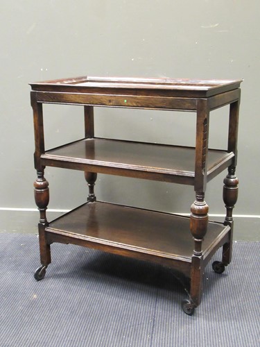 Lot 641 - An oak tea trolley with detachable tray top on...