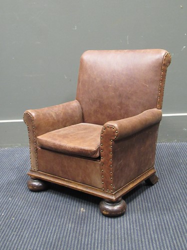 Lot 619 - A leather upholstered child's easy chair on...