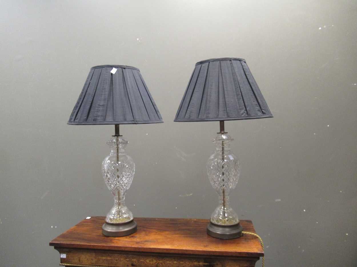 Lot 656 - A pair of cut glass lamp bases, with shades