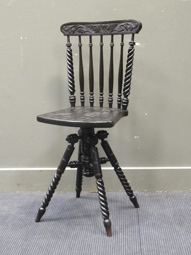 Lot 533 - An Arts & Crafts ebonised revolving chair with...