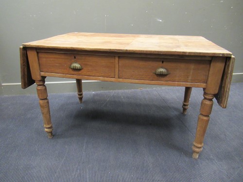 Lot 572 - A pine drop leaf table with two drawers on...