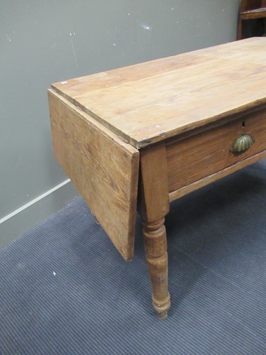 Lot 572 - A pine drop leaf table with two drawers on...