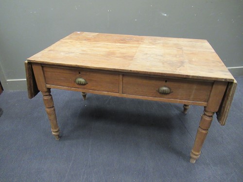 Lot 572 - A pine drop leaf table with two drawers on...