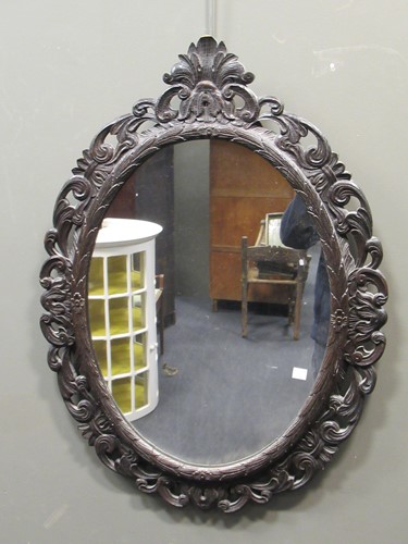 Lot 789 - An oval carved wood wall mirror together with...