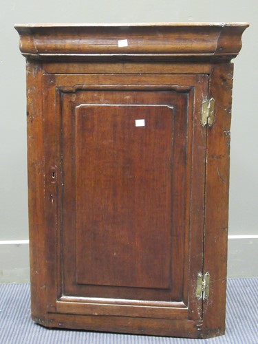 Lot 525 - A small George III oak hanging corner cupboard,...