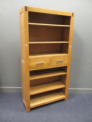 Lot 417 - A modern oak open bookcase with two central...