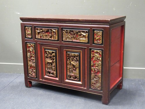 Lot 479 - A Chinese red painted cabinet, the carved gilt...