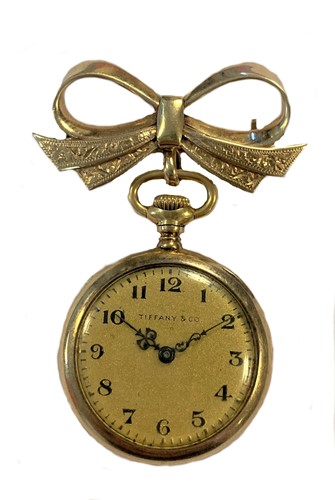 Lot 272 - Tiffany & Co. - An American 18ct gold open faced lapel watch with a later 9ct gold bow brooch